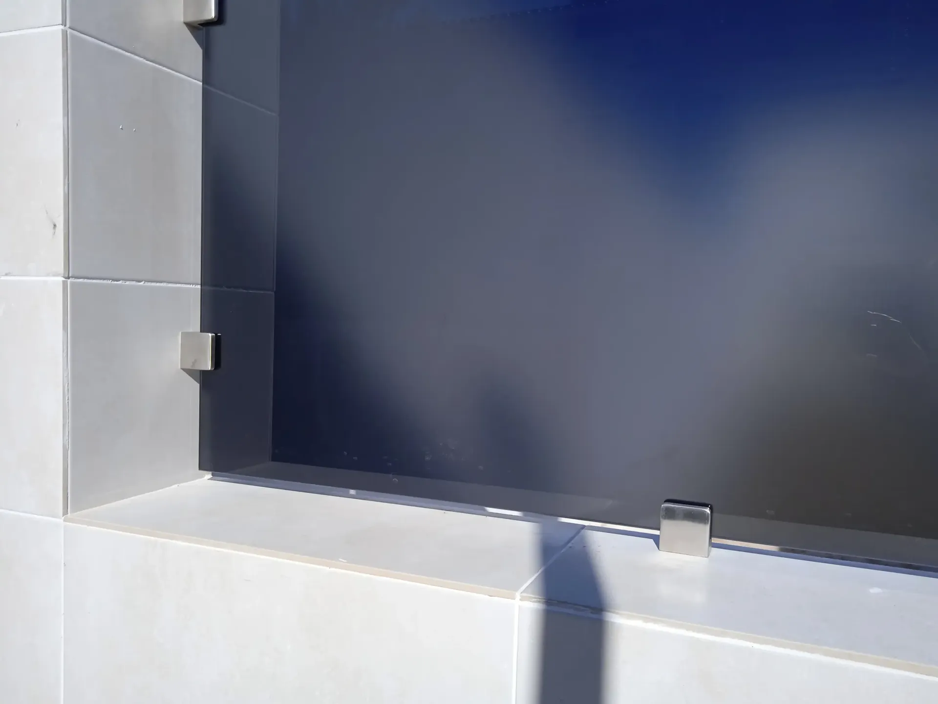 Una sombra de una persona se proyecta sobre una pared al lado de una ventana.