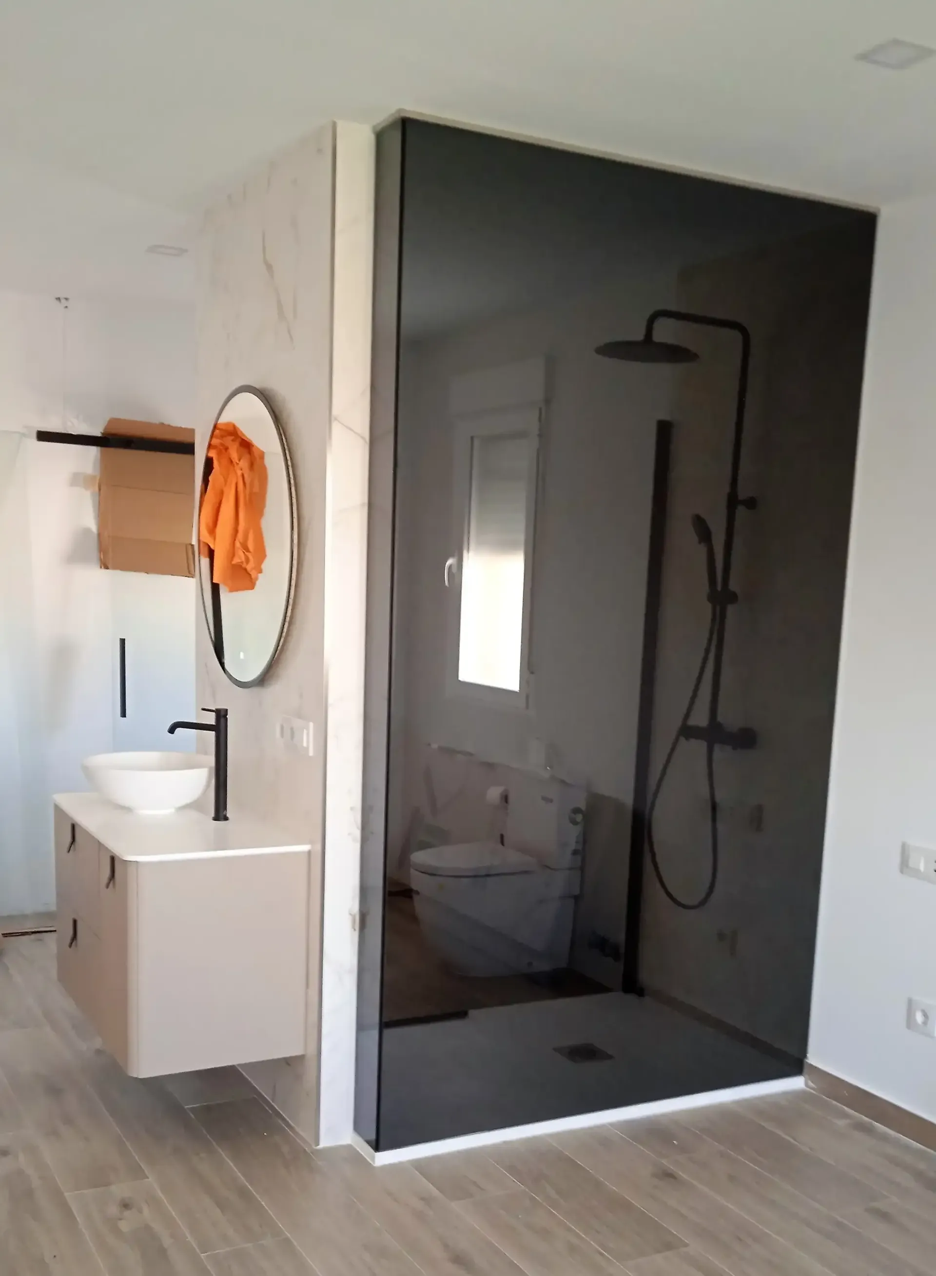 Un baño con ducha, lavabo, espejo e inodoro.