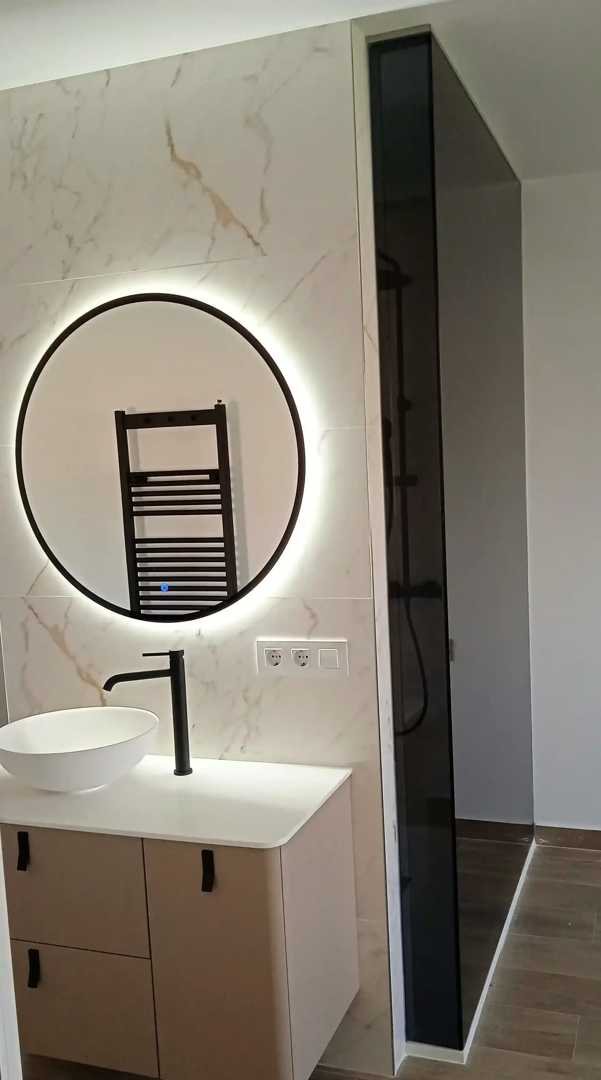 Un baño con lavabo, espejo y toallero.