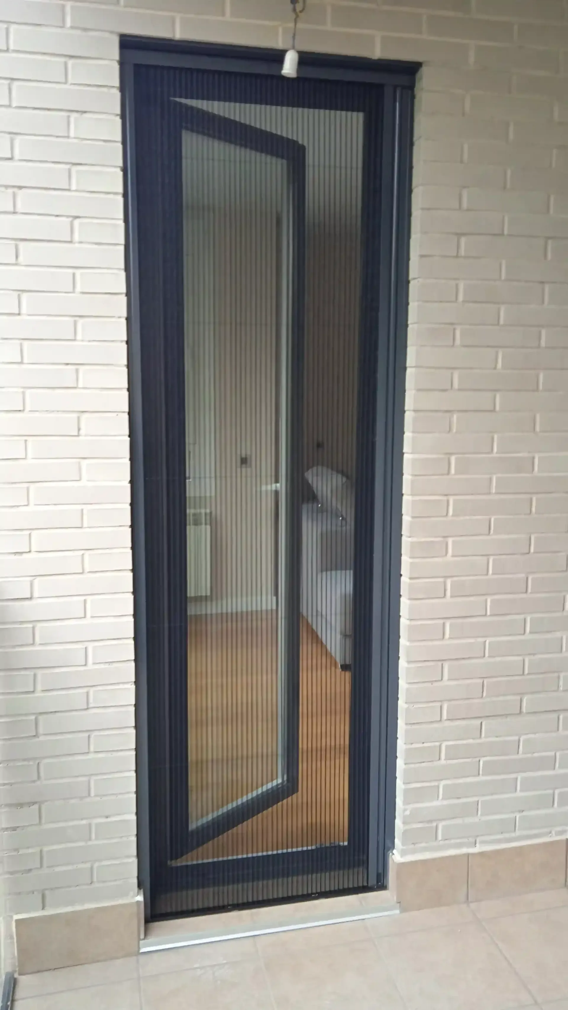 Una puerta corrediza de vidrio con un mosquitero adherido a ella.