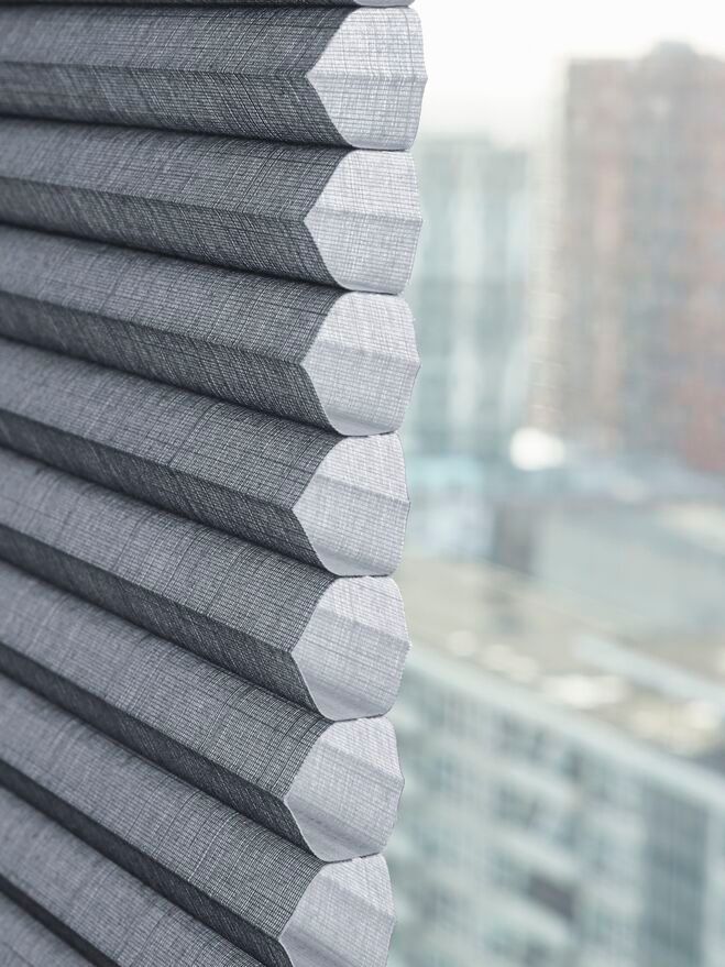 Un primer plano de una persiana de panal en una ventana.