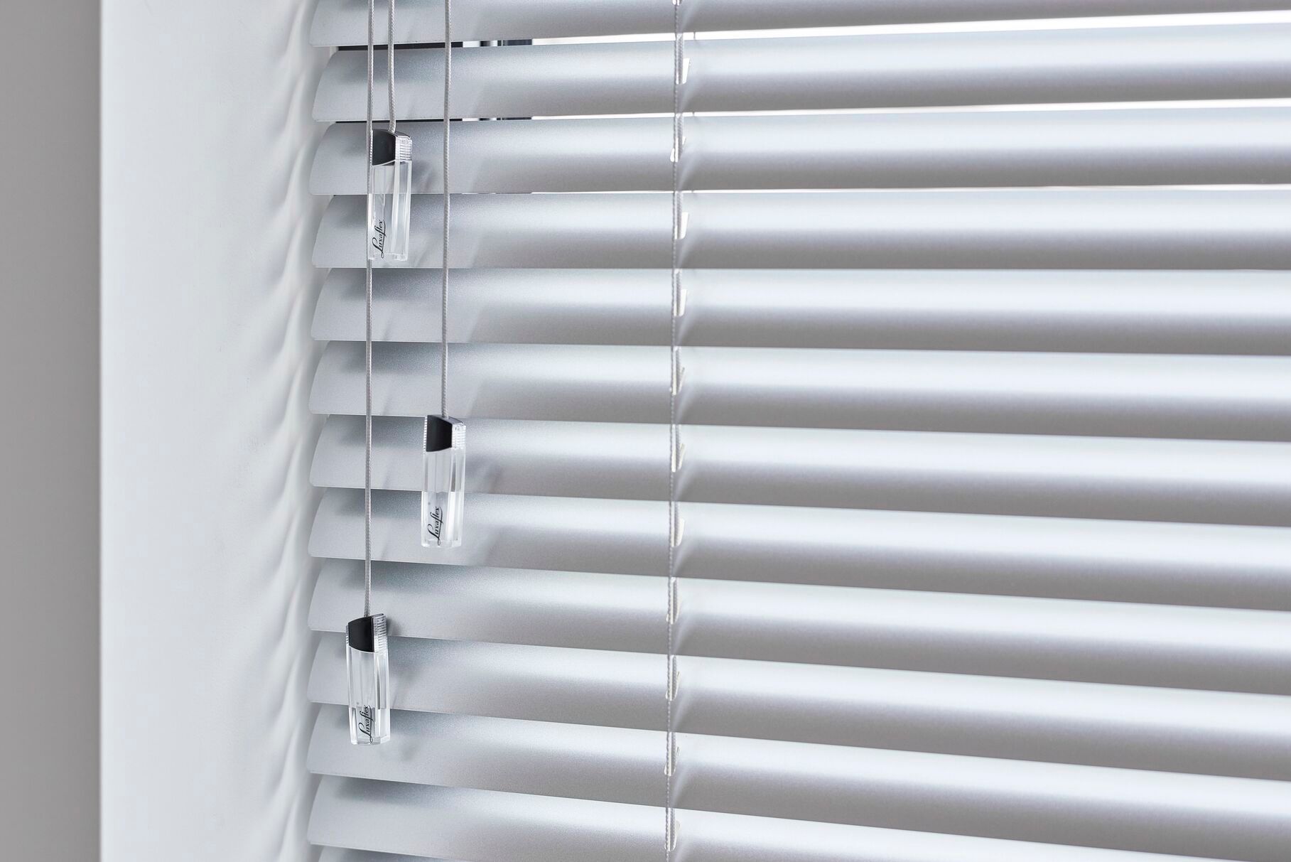 Un primer plano de una persiana blanca en una ventana.