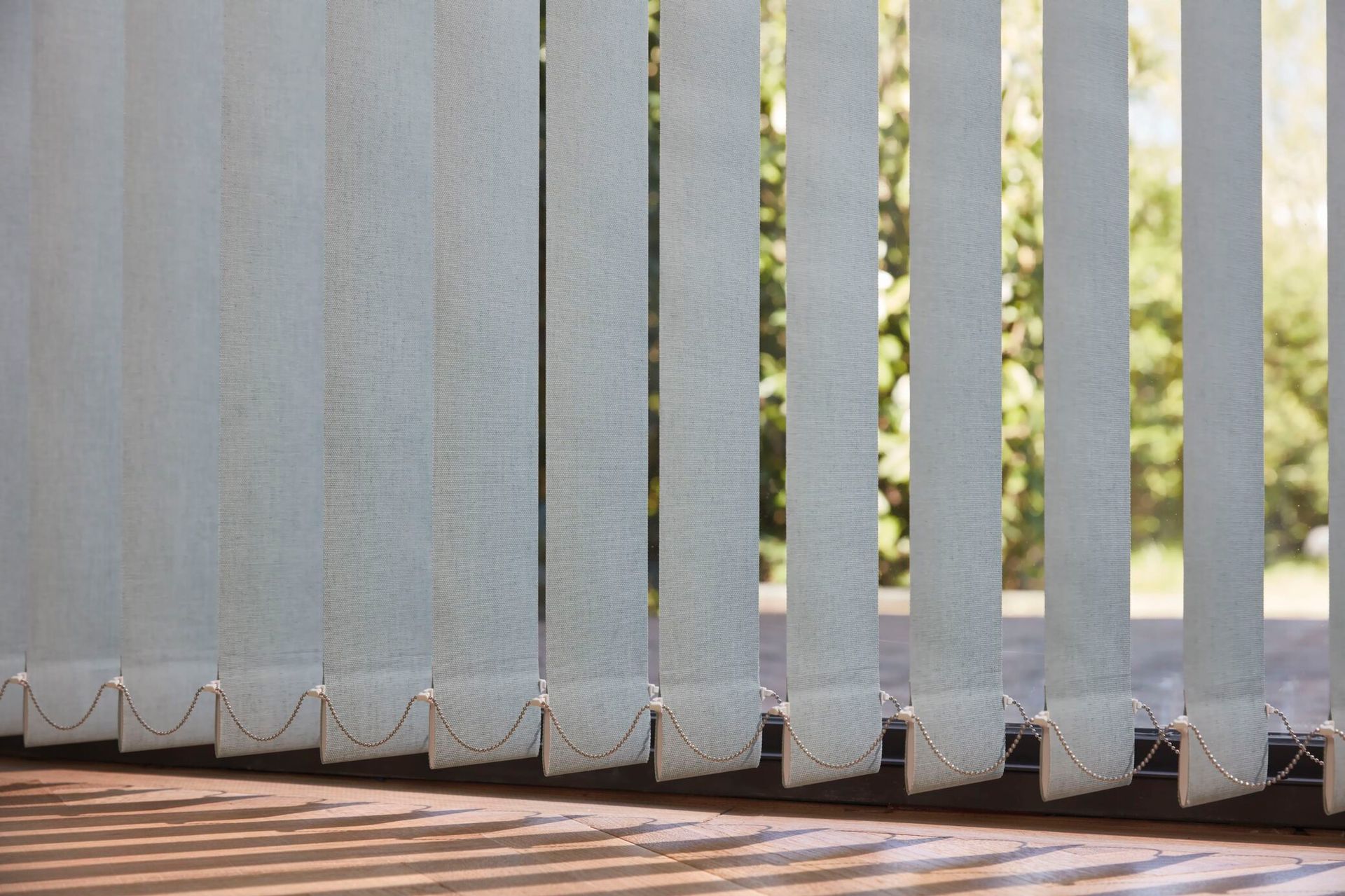 Un primer plano de una ventana con persianas verticales.