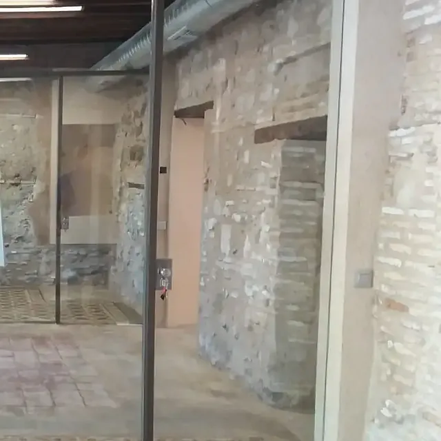 Una habitación con una pared de ladrillo y una puerta de vidrio