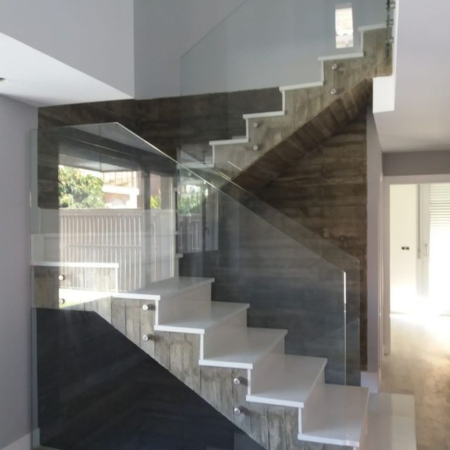 Una escalera con barandilla de cristal en una casa