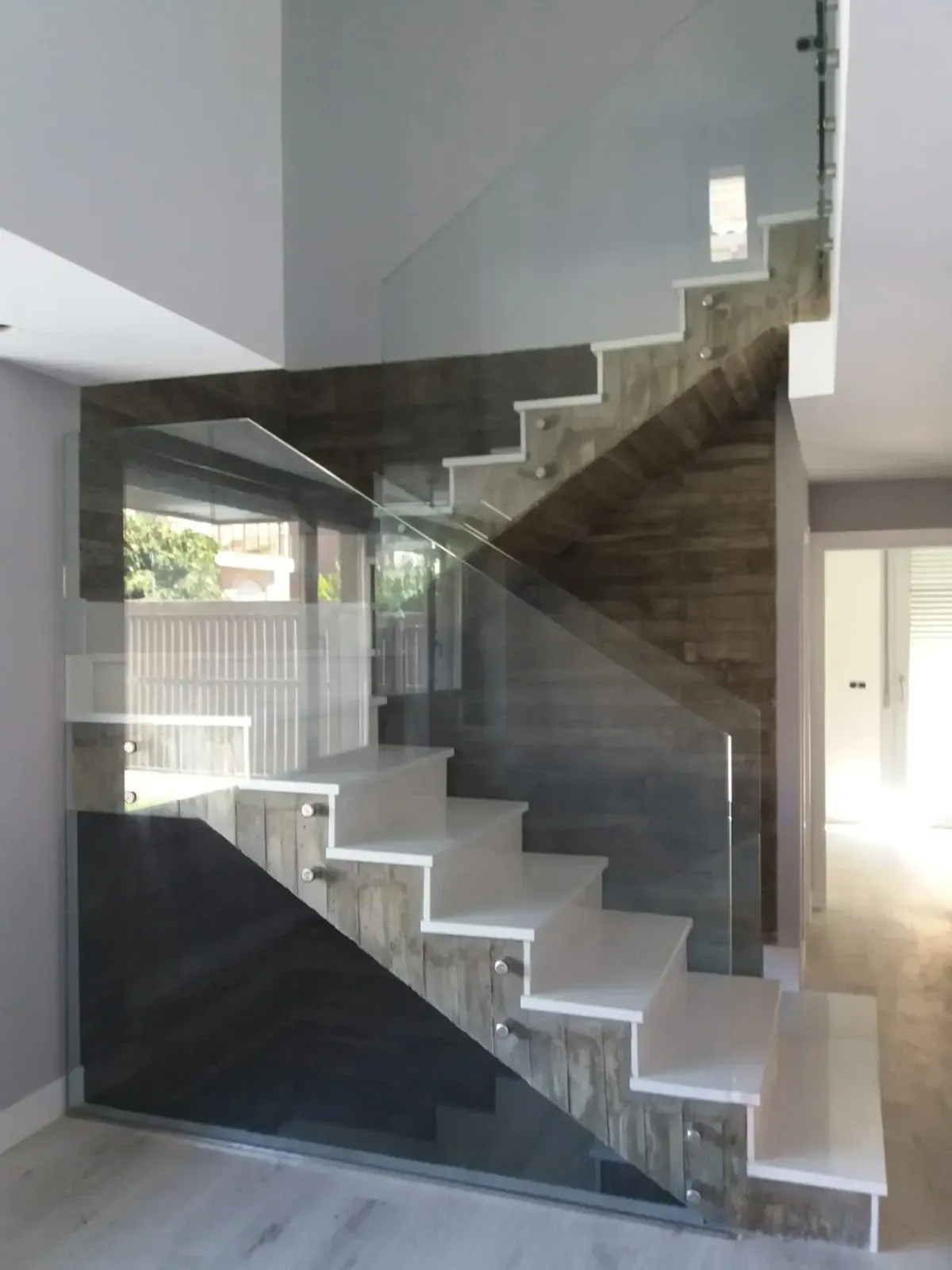 Una escalera con barandilla de cristal en una casa