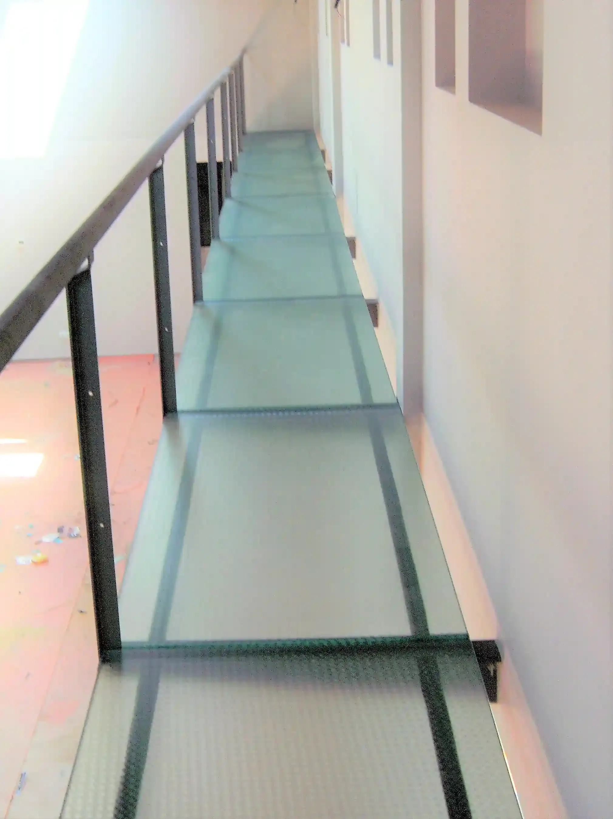 Un largo pasillo con suelo de cristal y barandilla.