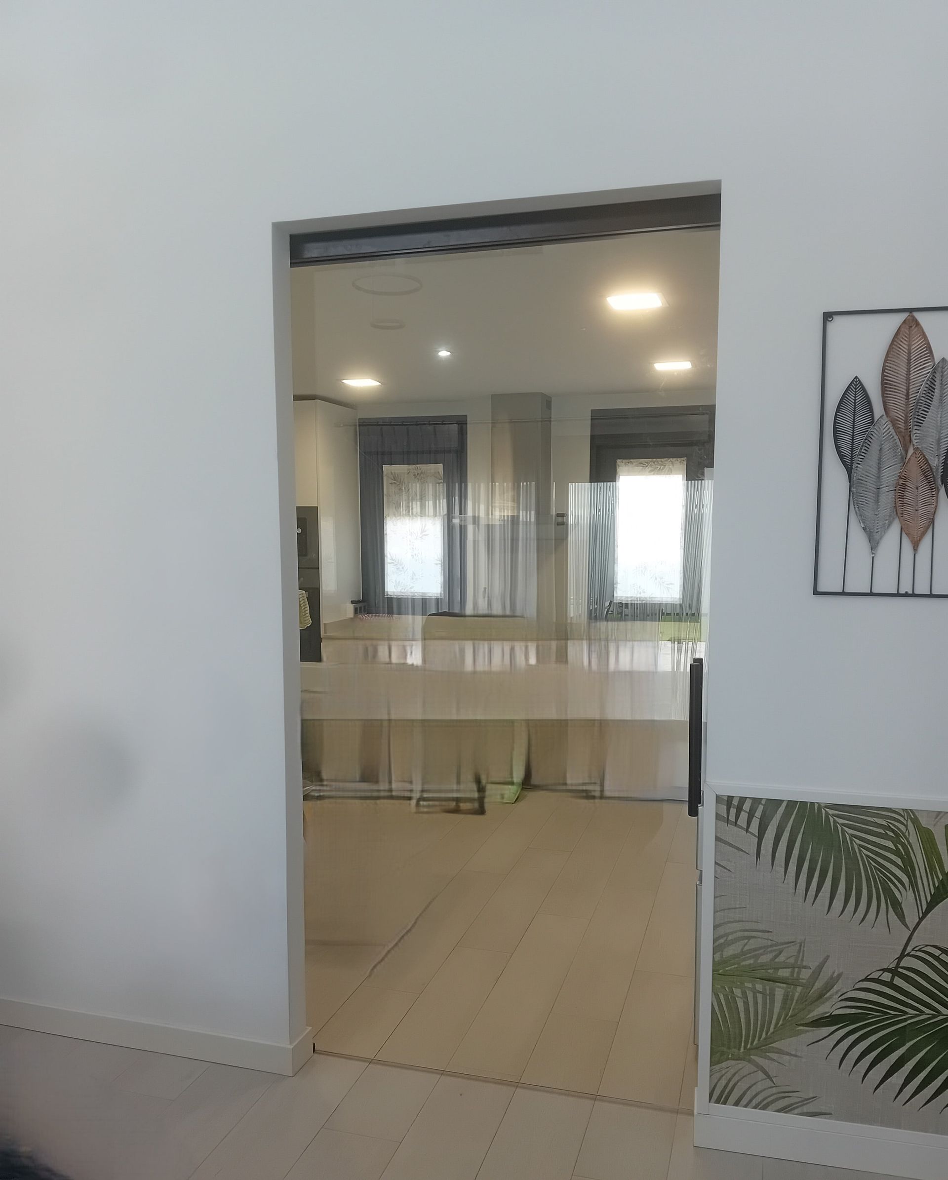 Una puerta que conduce a una cocina con un cuadro en la pared.