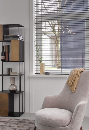 Una silla está colocada frente a una ventana en una sala de estar.