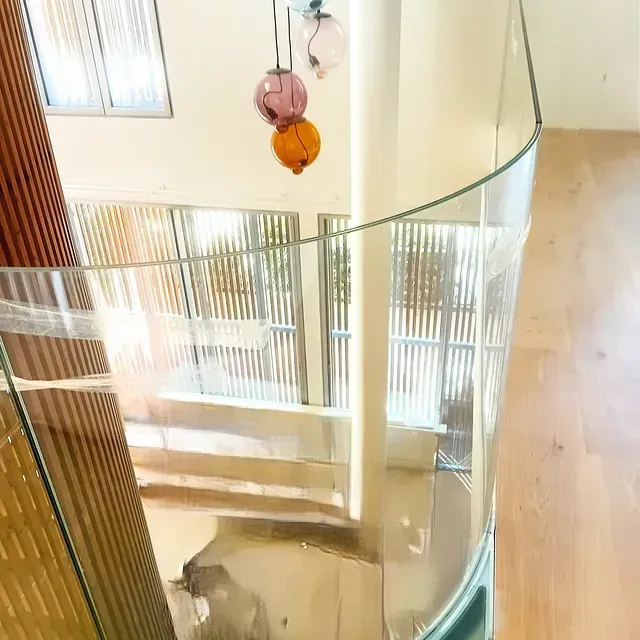 Una vista aérea de una escalera de caracol con barandilla de vidrio.