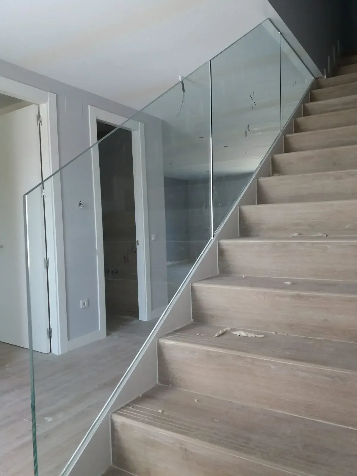 Un conjunto de escaleras con barandilla de vidrio en una casa.