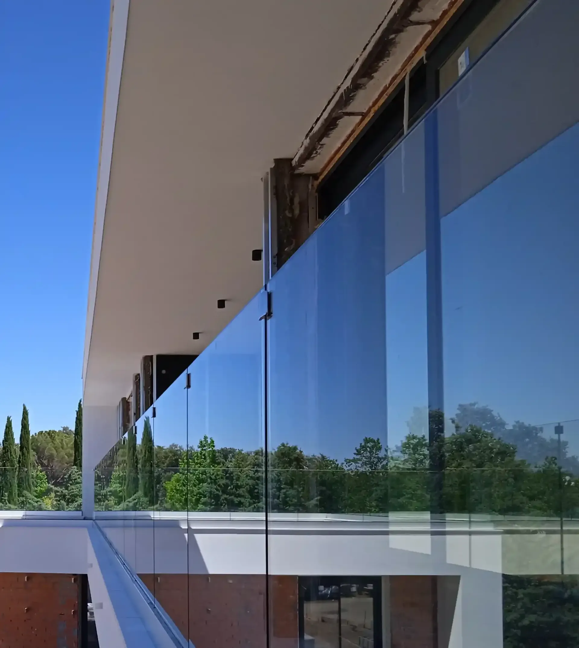 Un edificio con una barandilla de vidrio en el costado.