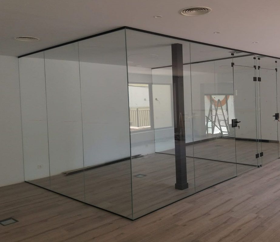 Una habitación con muchas paredes de cristal y suelo de madera.