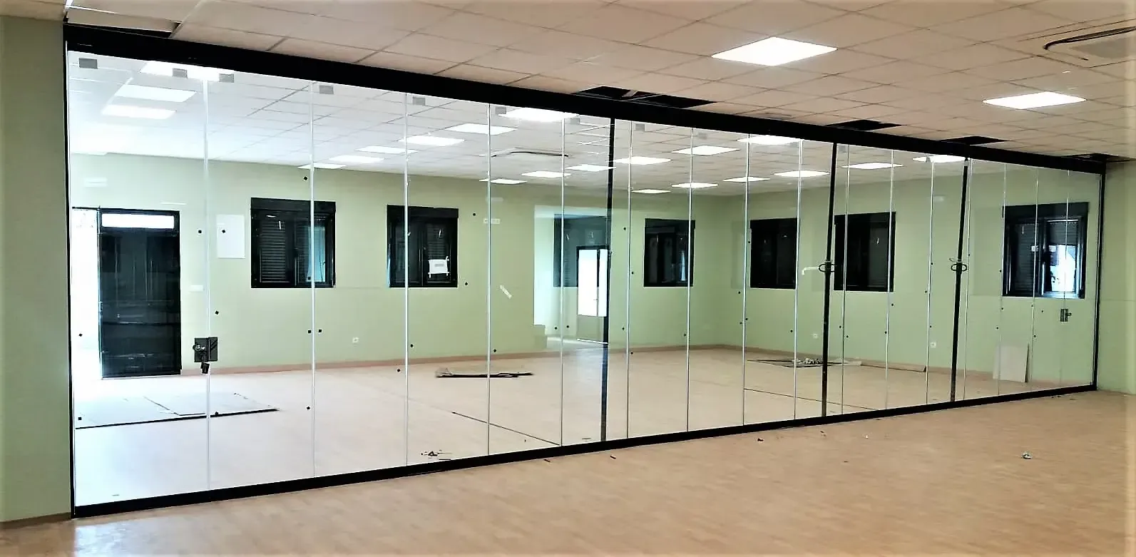 Una habitación grande con muchos espejos en la pared.