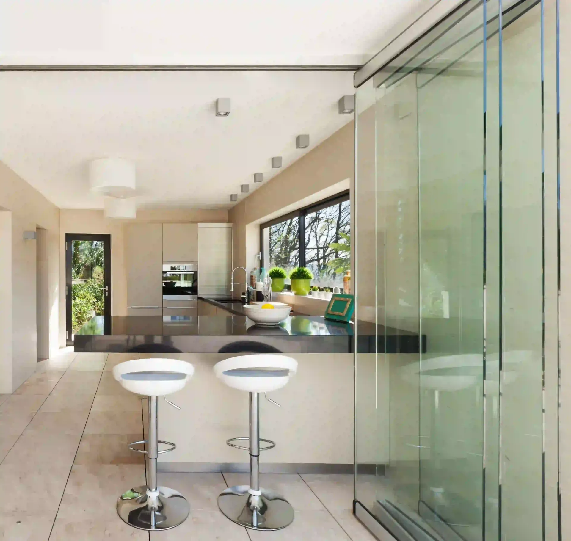 Una cocina con taburetes y una puerta corrediza de vidrio.