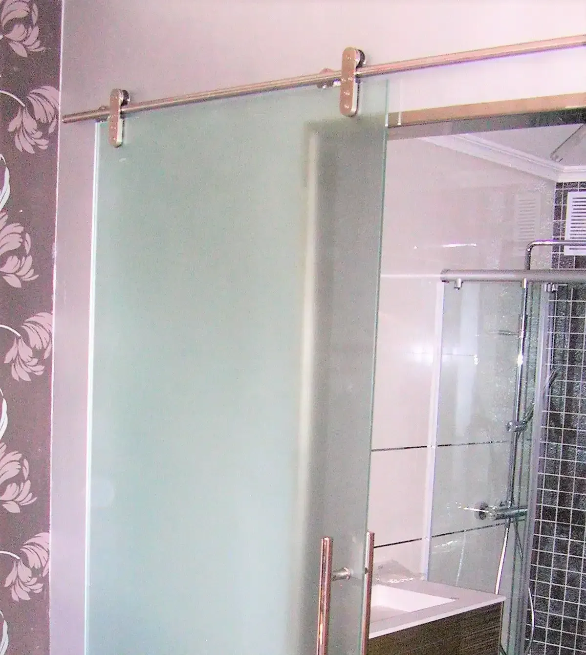 Un baño con puerta corrediza de cristal y lavabo.