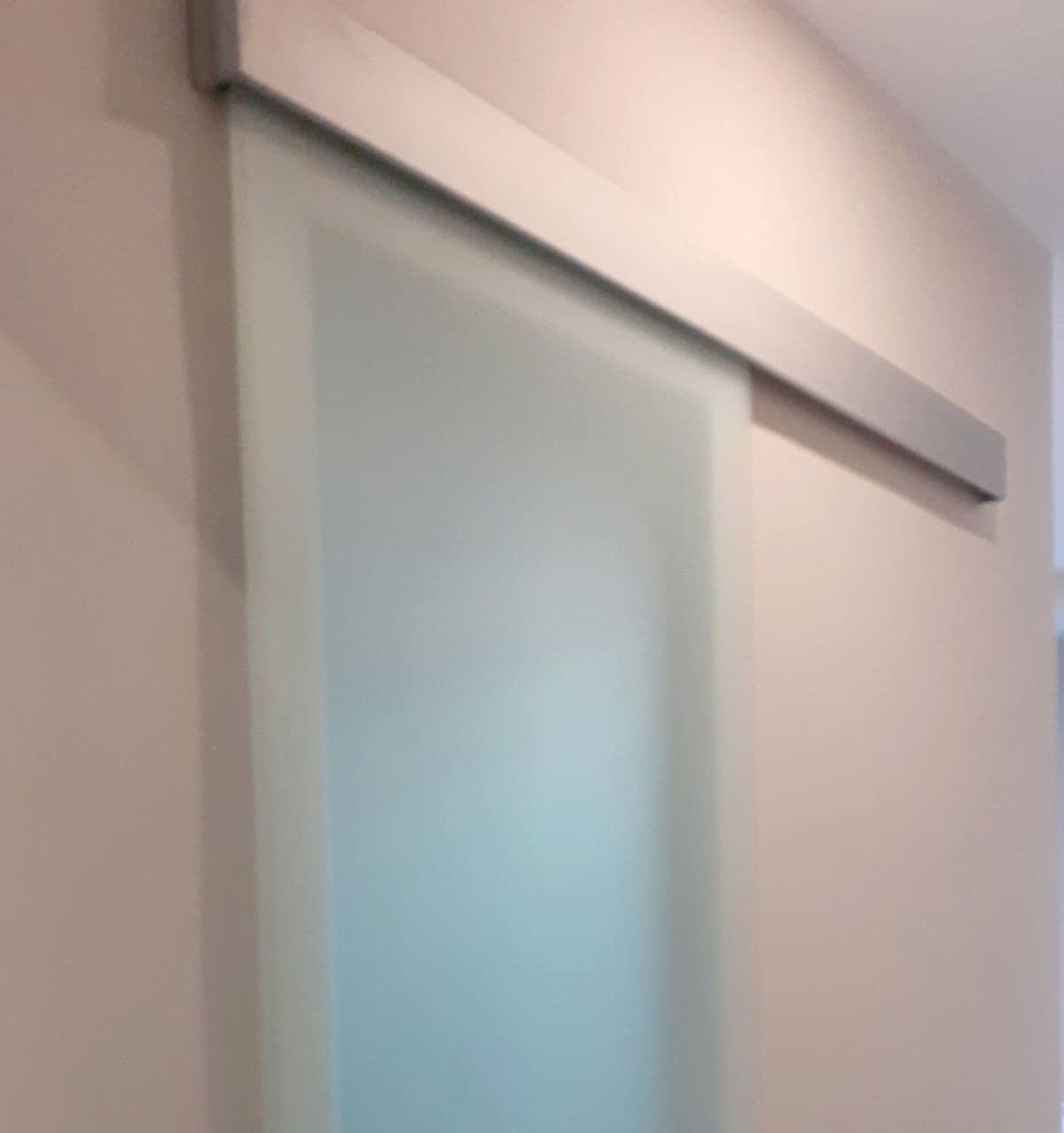 Un primer plano de una puerta corrediza de vidrio en un pasillo.