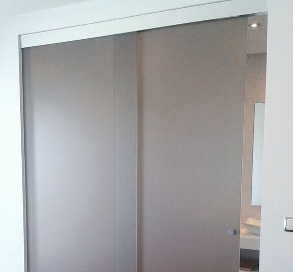 Una puerta corrediza de vidrio se abre a un baño.