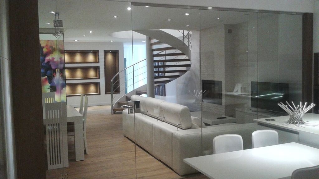 Una sala de estar con una escalera de caracol y una mesa y sillas.