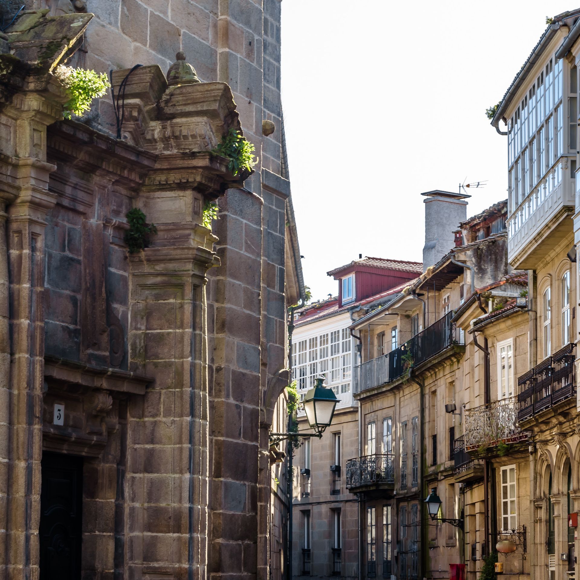 Una calle estrecha con algunos edificios y una farola.