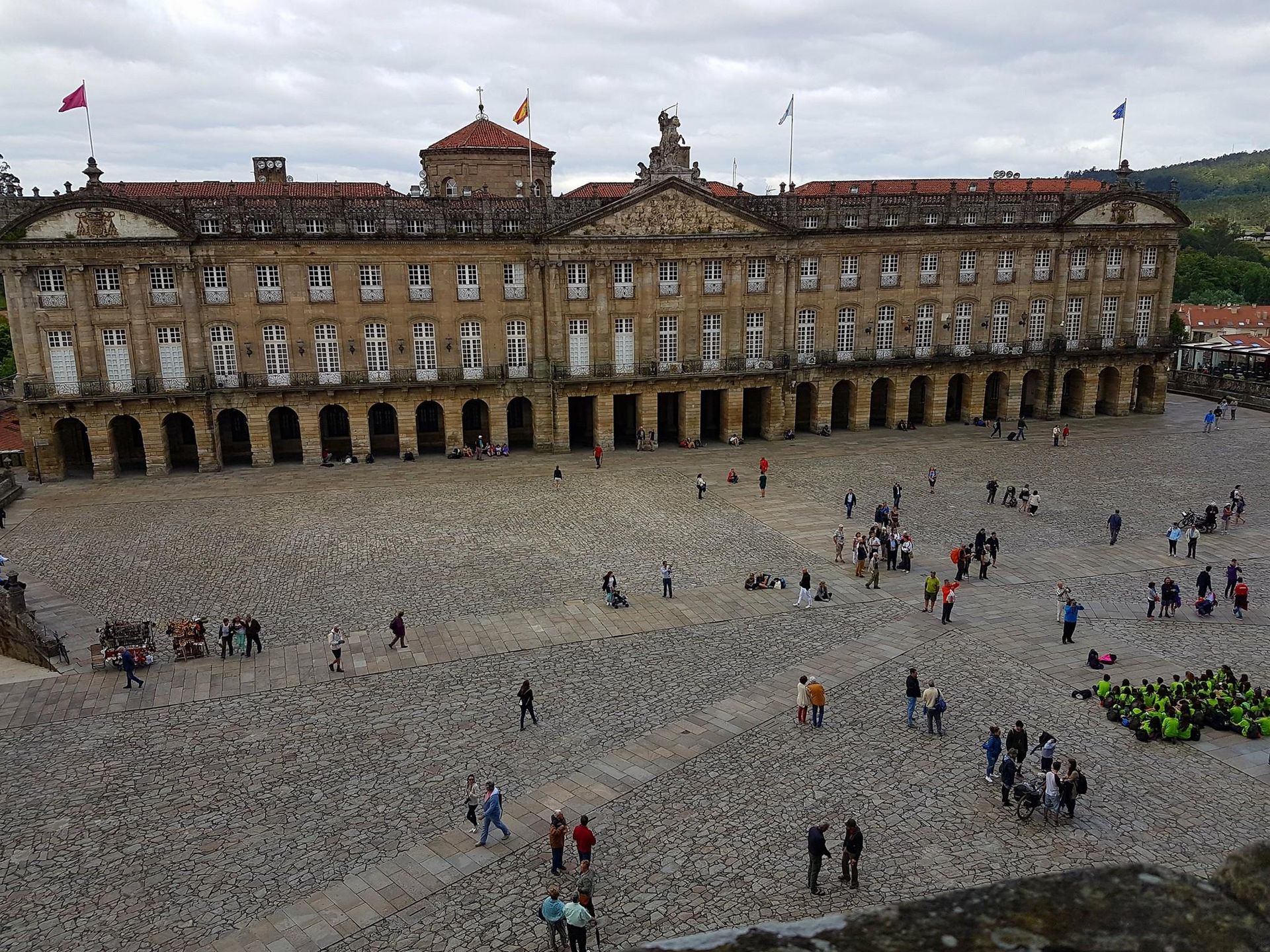 Un grupo de personas camina frente a un gran edificio.