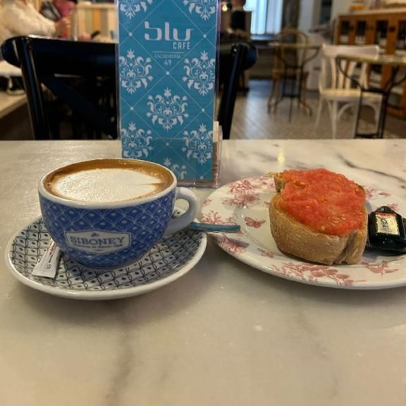 Una taza de café y un plato de comida en una mesa.