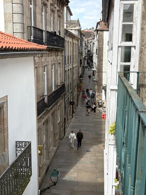 La gente camina por una calle estrecha entre dos edificios.