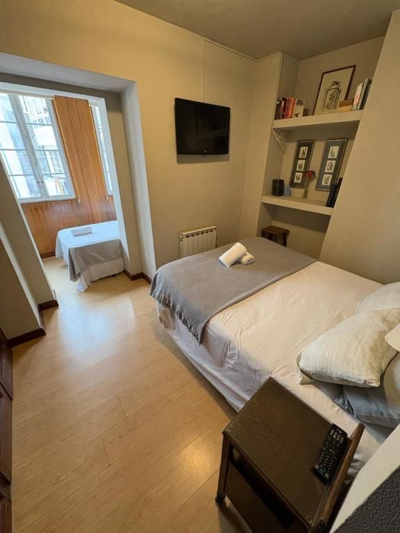 Un dormitorio con una cama grande y un televisor de pantalla plana.