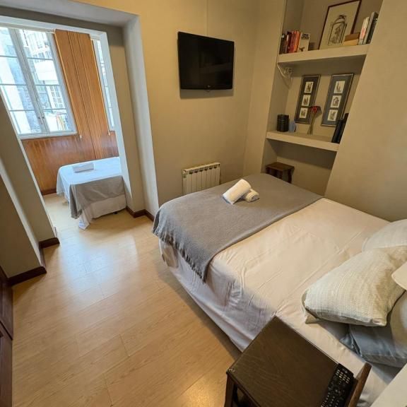 Un dormitorio con dos camas y un televisor de pantalla plana.