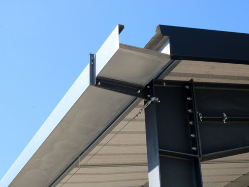 Gros plan sur un avant-toit de bâtiment avec des supports métalliques