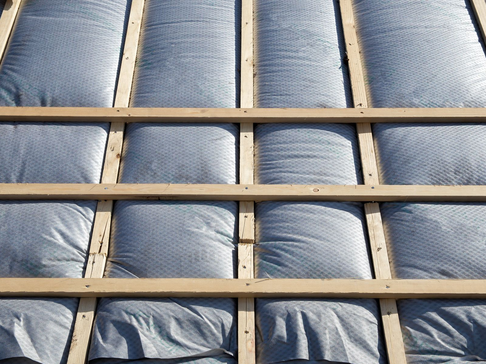 Surface matelassée bleue recouverte d'un motif en treillis de bois beige
