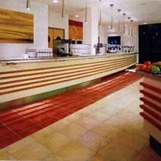 Moderne Ladeneinrichtung mit langer Verkaufstheke, heller Beleuchtung und Sitzbereich.