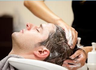 Lavado de cabello en el lavabo de una peluquería, con una persona recostada y los ojos cerrados.