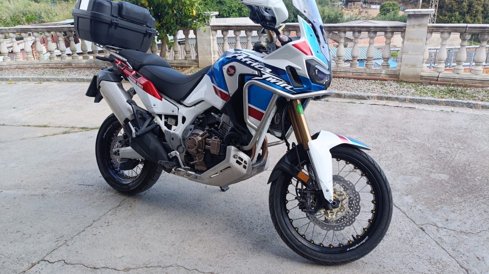 Un hombre conduce una motocicleta por un camino de tierra.