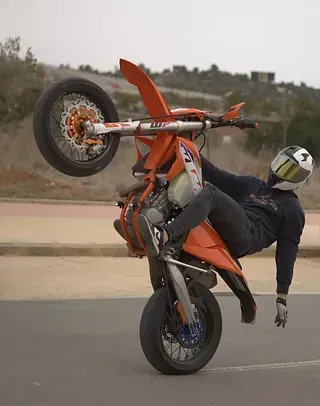 Un hombre está haciendo un truco en una motocicleta todoterreno.