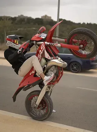 Una persona está haciendo un caballito en una motocicleta todoterreno.