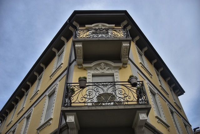 Un edificio giallo con un balcone all'angolo