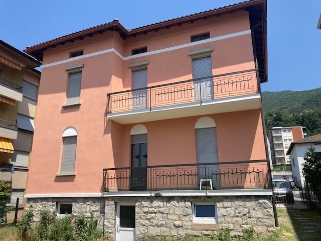 Un grande edificio rosa con un balcone al secondo piano