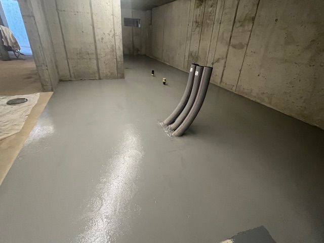 Una stanza con un muro di cemento e un pavimento di cemento.