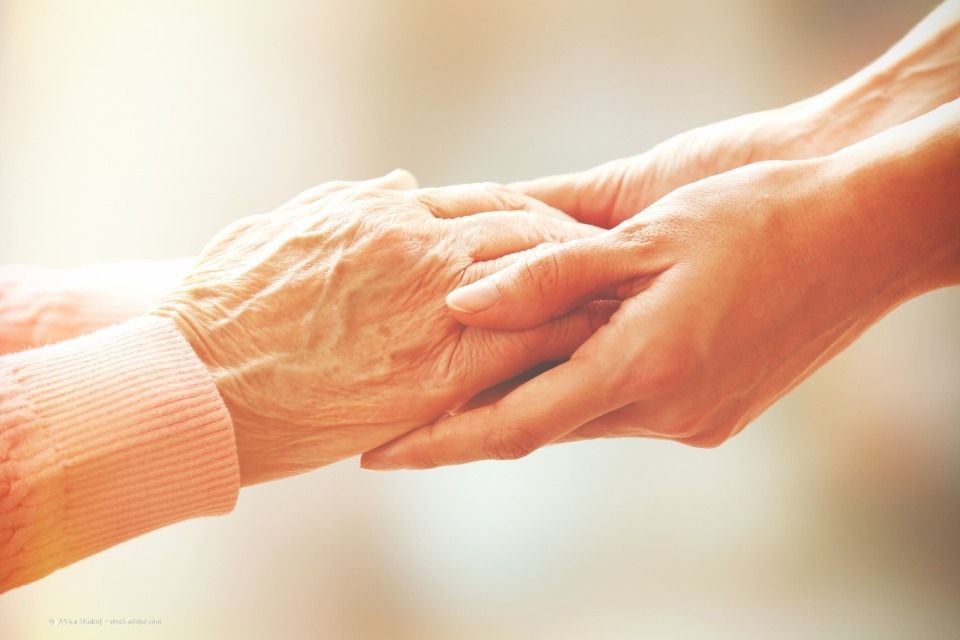 Mitarbeiterin der Ihre Pflege M3T GmbH hält Hand einer Seniorin