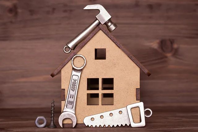 Una casa de madera con herramientas encima de ella, sobre una mesa de madera.