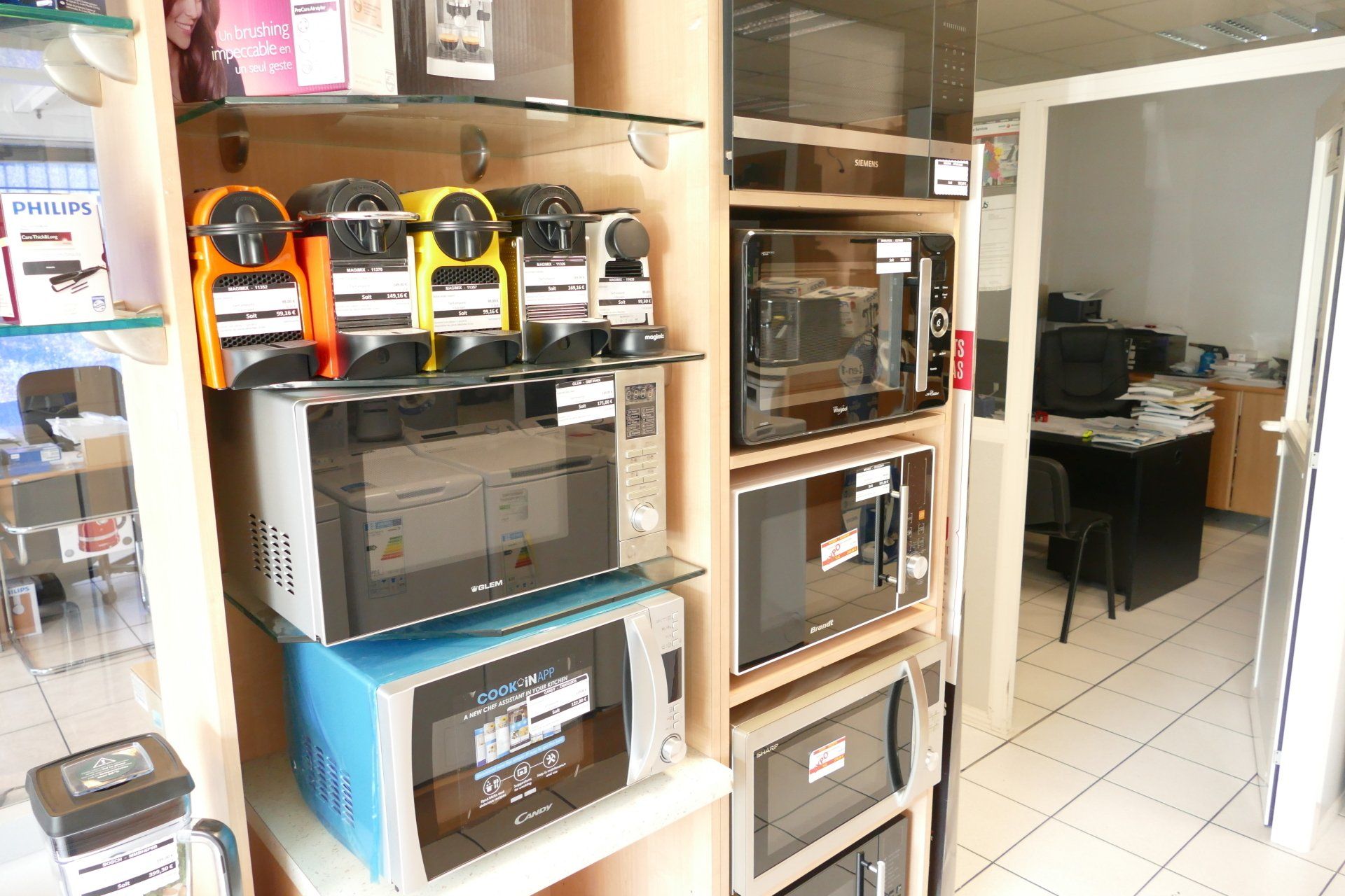 Sélection de micro-ondes et machines à café exposés dans le rayon d'un magasin