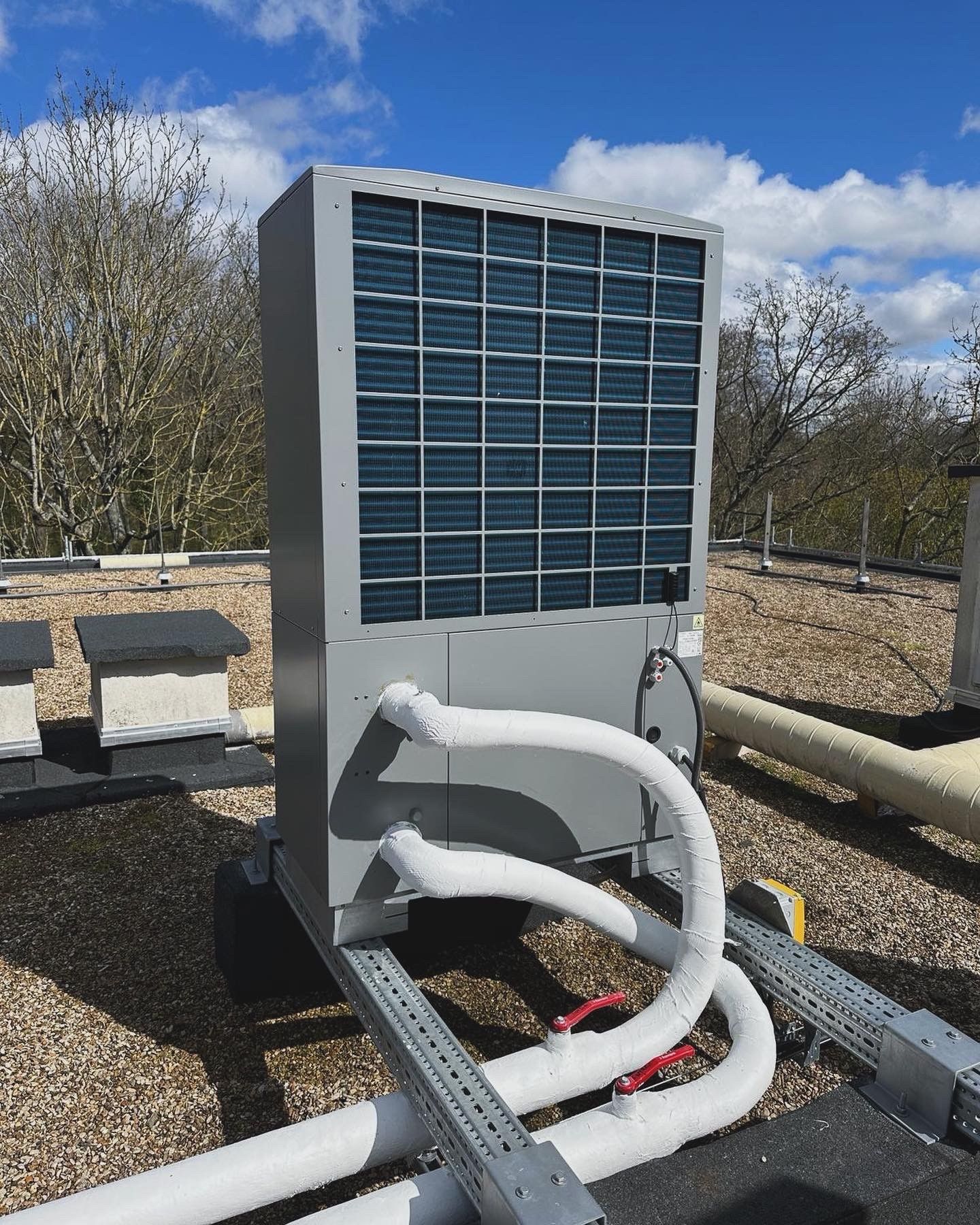 Une pompe à chaleur industrielle grise sur un toit.