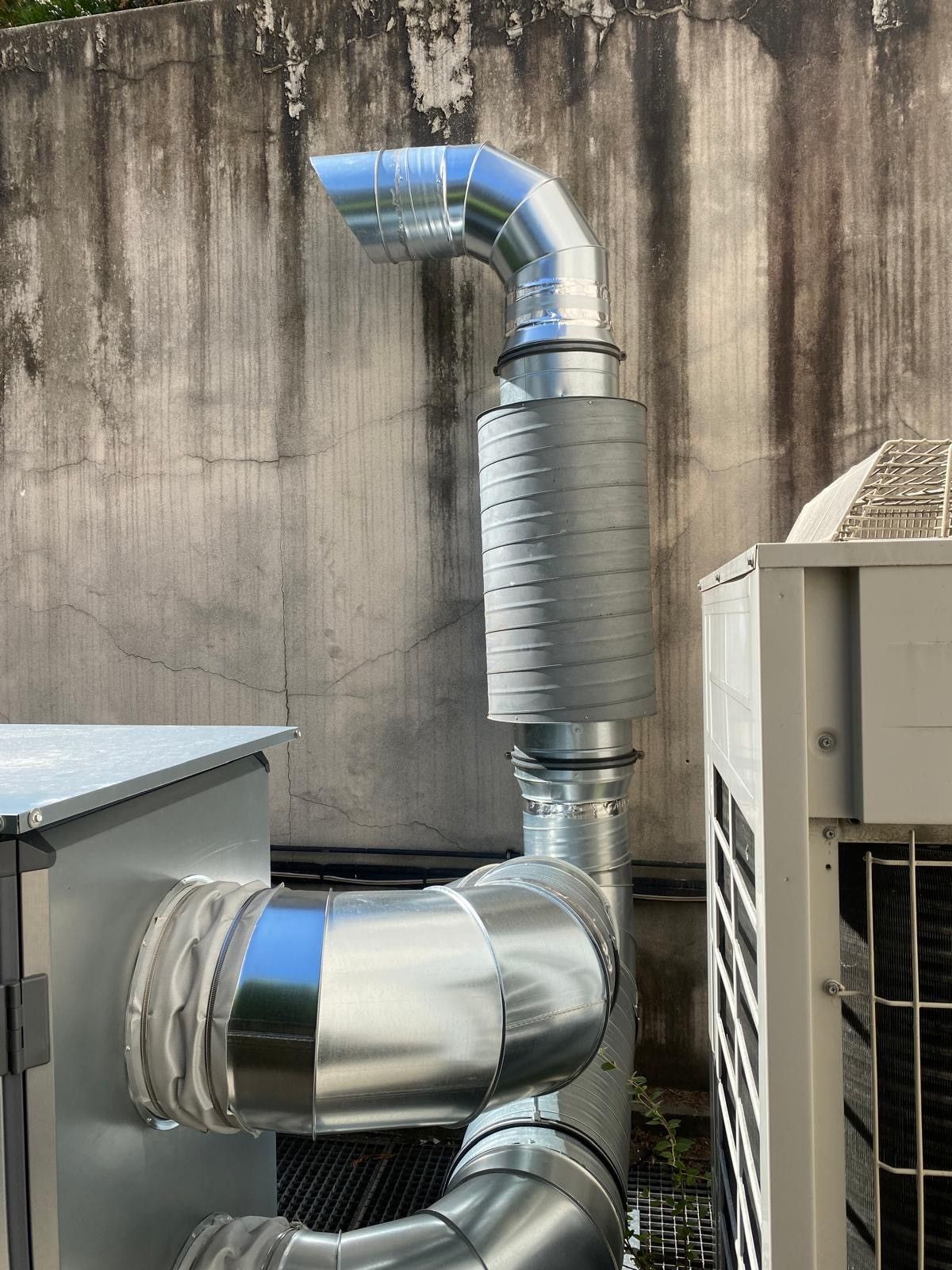 Un conduit de ventilation contre un mur.