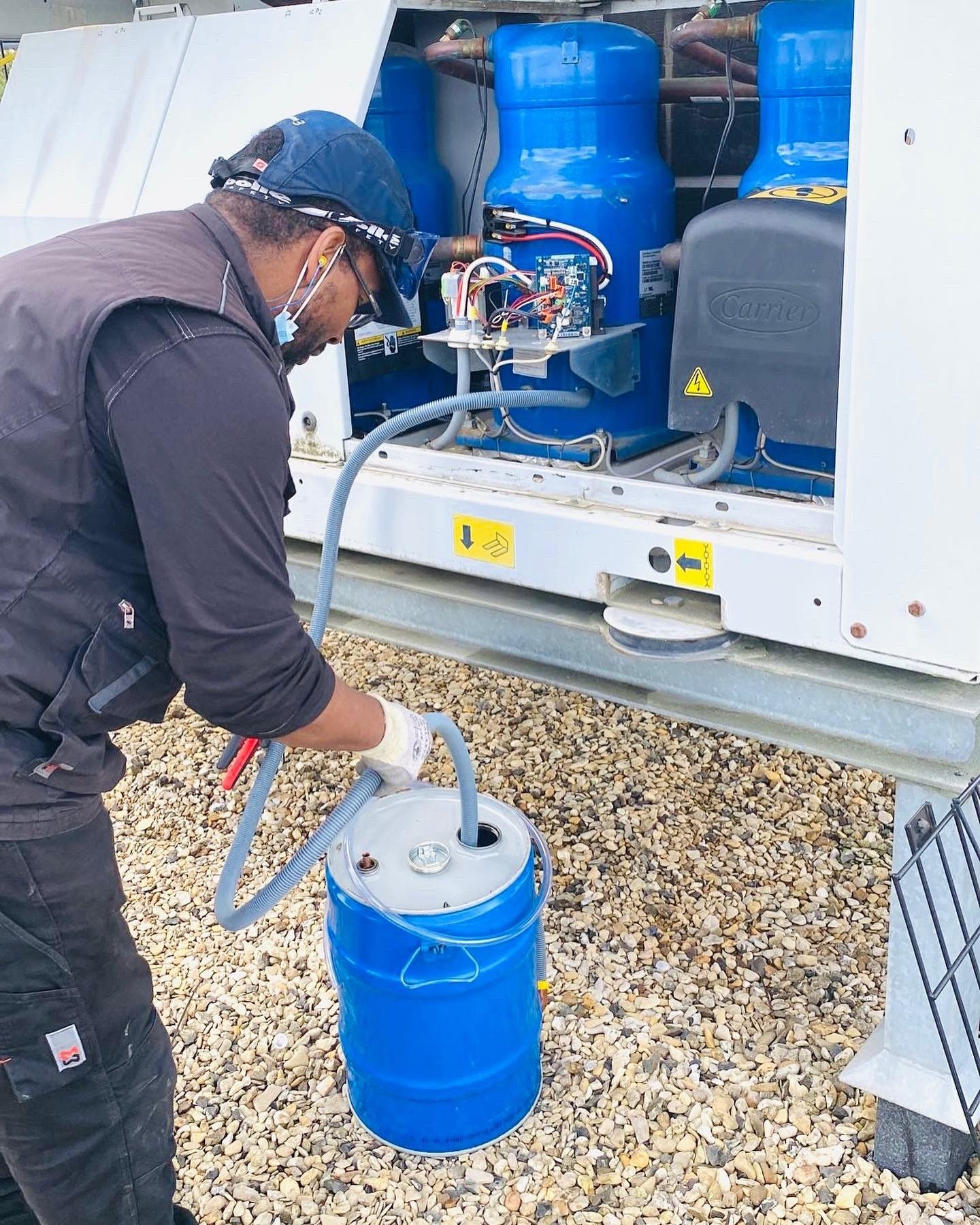 Un technicien entretient un équipement de refroidissement industriel extérieur.