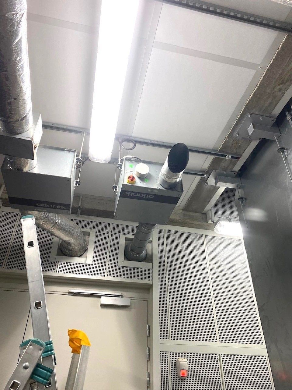 Un plafond montrant des boîtes de conduits électriques et des gaines.