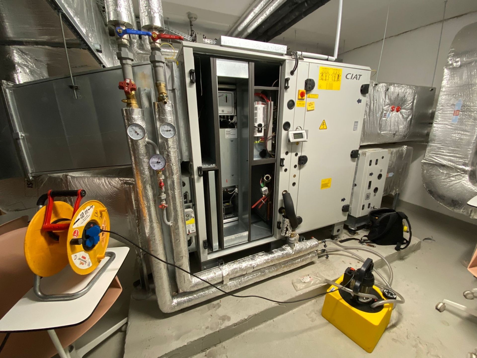 Une unité de traitement d'air CVC industrielle dans un local technique.