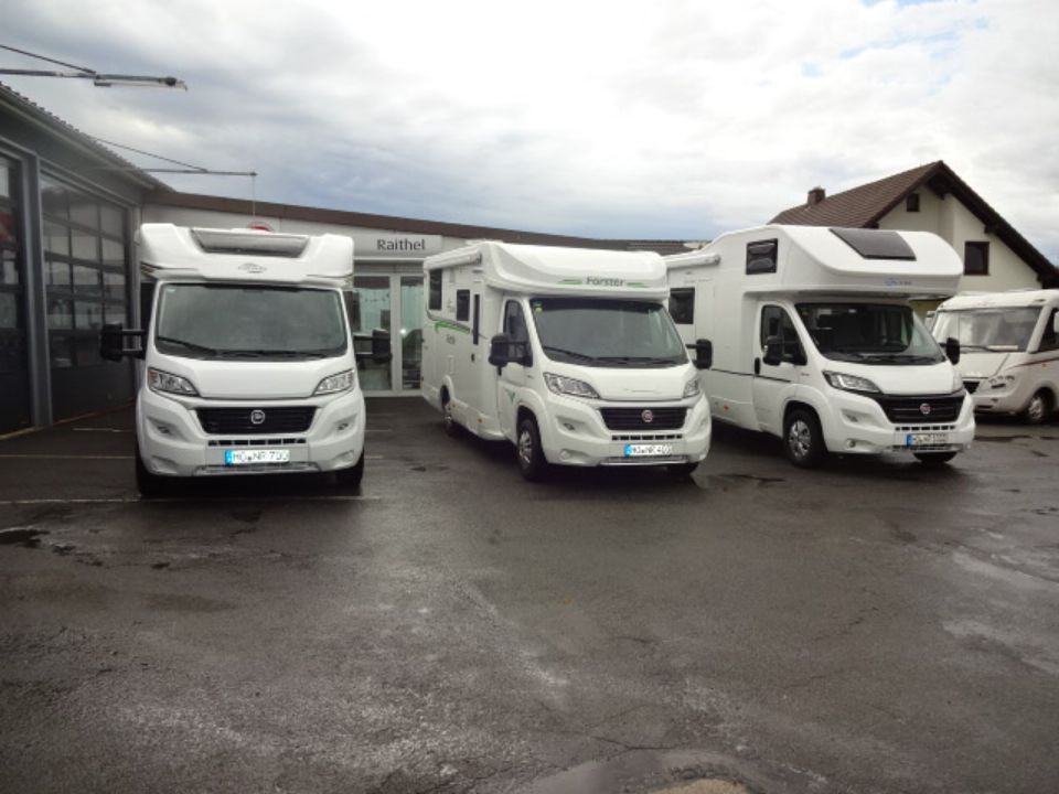 Drei Wohnmobile zur Vermietung im hof von Autohaus Raithel.