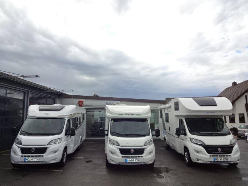 Drei Wohnmobile zur Vermietung im hof von Autohaus Raithel.