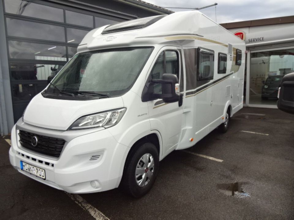 Weißes Wohnmobil Mitungsobjekt von rechts im Hof von Autohaus Raithel.